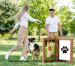 Scenic detail of a wooden pet paw print keepsake frame in a bright park setting