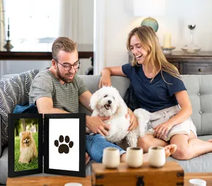 Detail of a black double hinged pet memorial frame featuring a dog photo and paw print