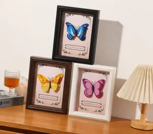 Detail view of 3D butterfly specimen frames in black, brown and white wood finishes.