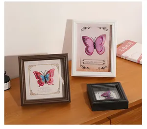 Decorative shadow box frames with butterfly specimens displayed on a wooden surface