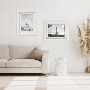Cornici per foto in legno bianco A4 minimaliste esposte come parete galleria in un soggiorno