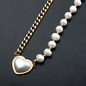 Close-up of heart pendant necklace featuring freshwater pearls and gold curb chain