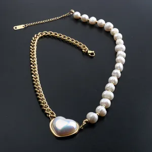 Close-up detail of a gold titanium steel necklace with heart pendant and pearls