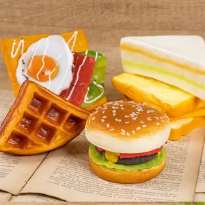 Realistic PU artificial food models set with burger, waffle, and sandwich on vintage book.