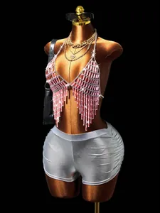 Detailopname van een roze kristallen franje bodychain met zilveren metallic rave shorts.