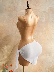 Detailed back view of bohemian beaded halter top with white beach wrap on mannequin