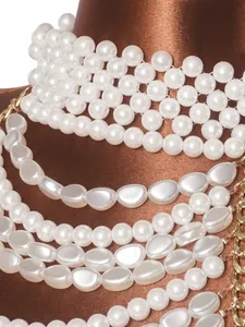 Macro view showing elegant multi-layer white pearls and gold chain details on top