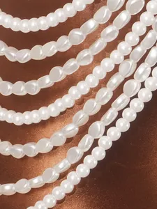 Close-up detail of an elegant handmade multi-layer pearl halter top against brown satin
