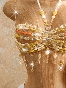 Detailed macro view of bohemian handmade beaded halter top with sparkling tassels and gold chains