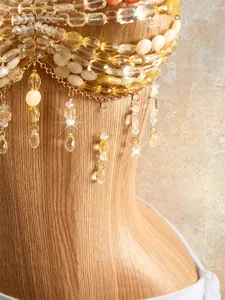 Macro view of bohemian handmade beaded halter top with yellow amber resin fringes and chain