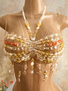 Close-up of handmade Bohemian beaded bralette with intricate yellow and orange tassels.