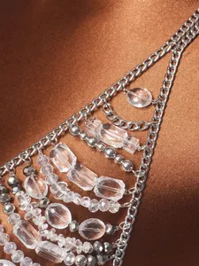 Macro di perle di cristallo e catena per il corpo in argento su raso marrone.