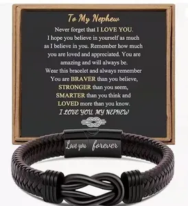 Dettaglio bracciale in pelle intrecciata con chiusura magnetica incisa e cartolina regalo