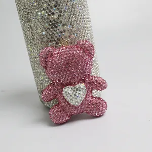 Close-up of pink rhinestone-encrusted bear pendant with a central white heart motif