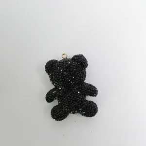 Macro view of a sparkling black rhinestone bear charm with a gold attachment loop