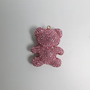 Close-up of a sparkling pink rhinestone-studded teddy bear pendant keychain accessory detail.