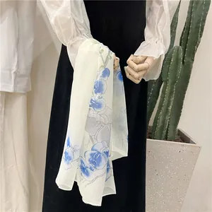 Detail of lightweight chiffon scarf with blue orchid floral print on wooden mannequin