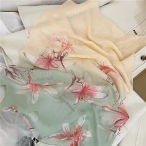 Close-up detail of lightweight chiffon scarf featuring elegant pink lily floral prints