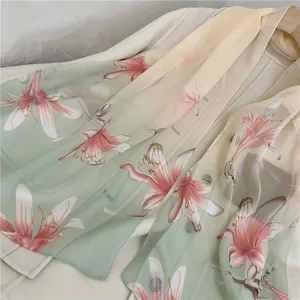 Close-up of elegant floral print chiffon scarf with green and cream color gradient