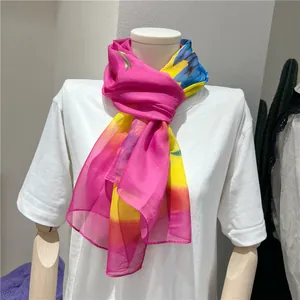 Bright pink and yellow floral chiffon long scarf displayed on a white mannequin