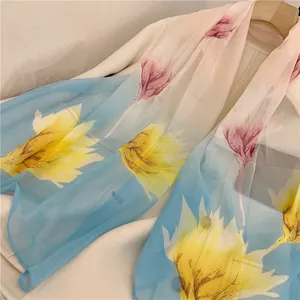 Detailed view of lightweight sheer chiffon long scarf with vibrant yellow and pink floral prints