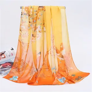 Detail view of a long chiffon scarf with elegant magpie and floral print in orange.