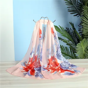 Detailed macro view of lightweight floral print chiffon scarf in elegant peach and blue