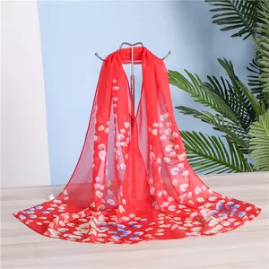 Elegant red chiffon long scarf with white and blue floral petal print on display