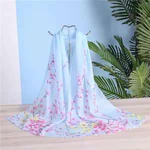 Detail of light blue floral print chiffon scarf for women, elegant long neck wrap shawl.
