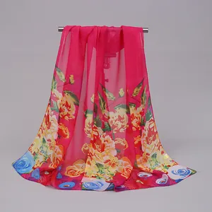 Detail of pink chiffon long scarf with vibrant floral print draped on a hanger