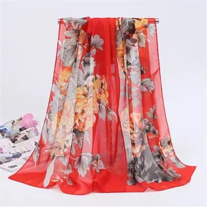 Elegant detailed view of red long chiffon scarf featuring yellow floral print patterns