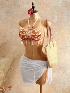 Detailed view of bohemian handmade beaded halter top with red tassels for beachwear