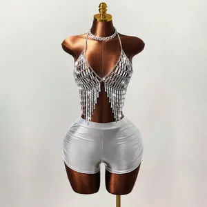 Detailweergave van de sprankelende strass-lichaamsketting en zilveren metallic shorts