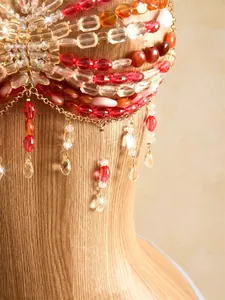 Close-up shot of bohemian handmade beaded halter top with red crystal tassels and gold chains
