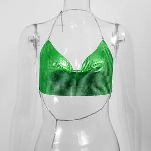 Gedetailleerd zicht op het levendige groene metalen gaas op de halter crop top.