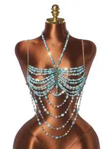 Vista detallada de una cadena de cuerpo con perlas acrílicas turquesas en un maniquí.