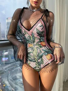 Detailed view of women's black long sleeve rhinestone mesh dress over pineapple print swimsuit