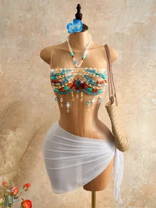 Detail of Bohemian beaded halter top with colorful gems and tassels on mannequin.