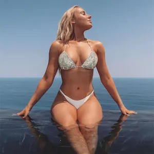 Detail view of a glamorous sequined bikini top with a serene ocean background