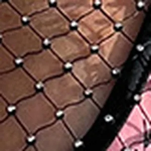 Close-up view of the black mesh dress fabric featuring shimmering crystal rhinestone studs