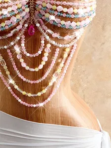 Dettaglio di una catena per il corpo con perline colorate e ciondolo a goccia rosa