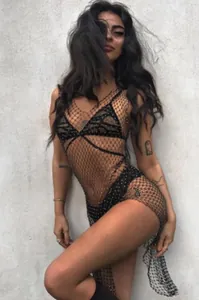 Detalle del vestido de rejilla negra con pedrería brillante y escote en pico profundo