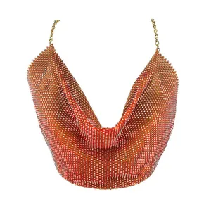 Detalle de top halter de malla con pedrería naranja brillante y cadenas doradas finas