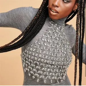 Close-up detail of a shimmering gemstone mesh body chain vest worn by a fashion model.
