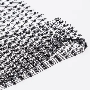 Macro view of sparkly rhinestone detail on black fishnet mesh fabric for sexy vest