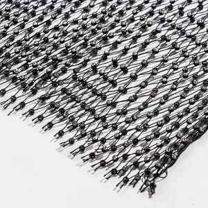 Macro detail of black fishnet fabric with sparkling rhinestone accents for sexy vest