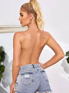 Detailweergave van een sexy rugloze haltertop met een dunne zilveren tailleketting