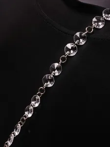Vue rapprochée d'une chaîne en cristal transparent sur un haut de mode noir chic