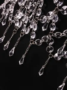 Gros plan d'une chaîne de corps en métal argenté avec franges en cristal sur fond noir