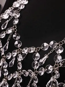 Vue détaillée d'une chaîne de corps à franges en cristal transparent avec maillons.